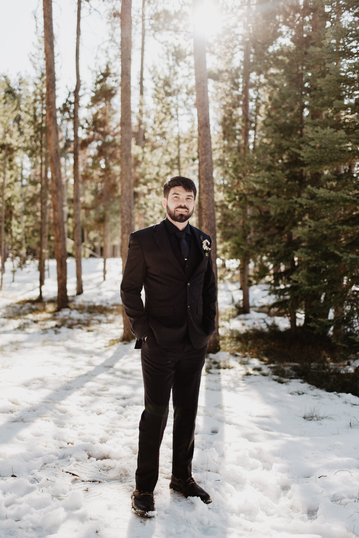 Jackson Hole Photographers capture groom standing in snowy forest