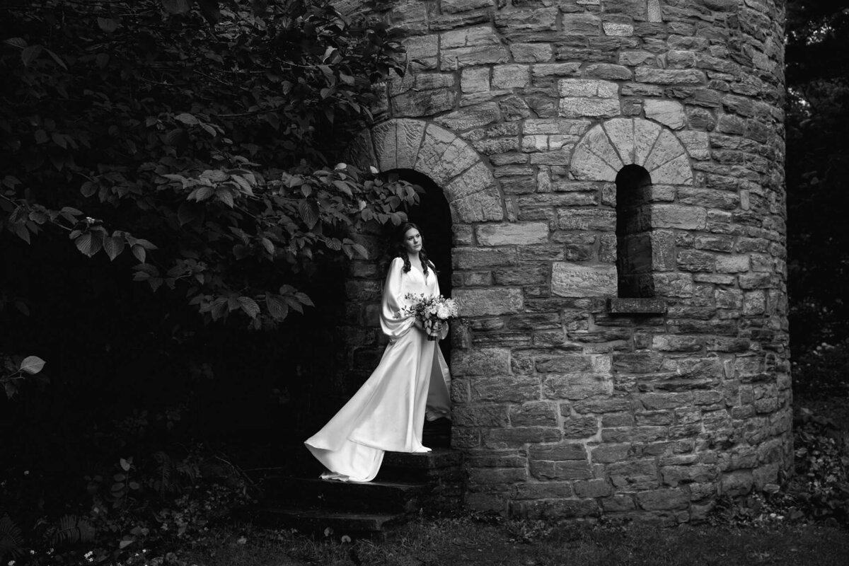 Black and white portrait of bride holding a bouquet at a castle Duke Sculpture Garden at Dixon Mansion