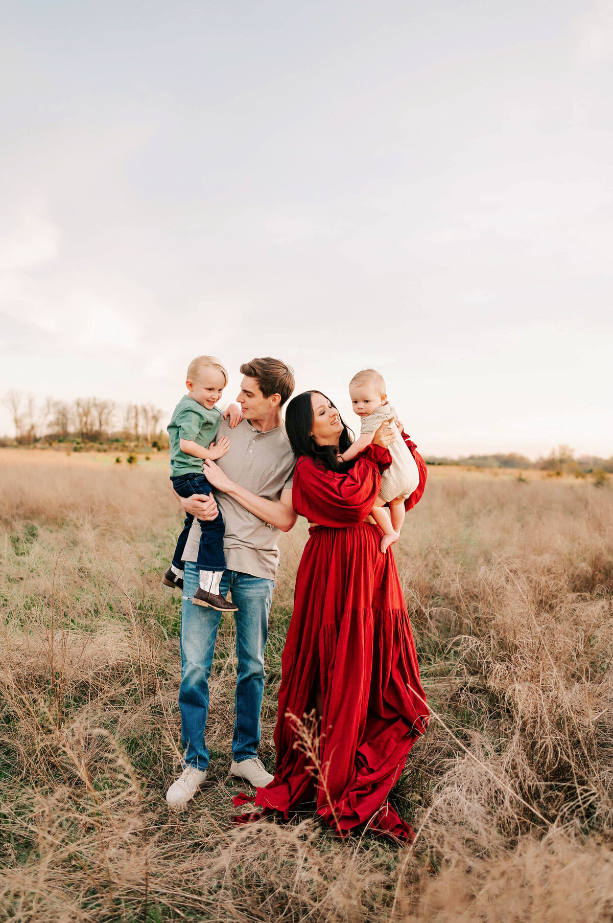 family picture of family playing together in a field in Branson MO at sunset