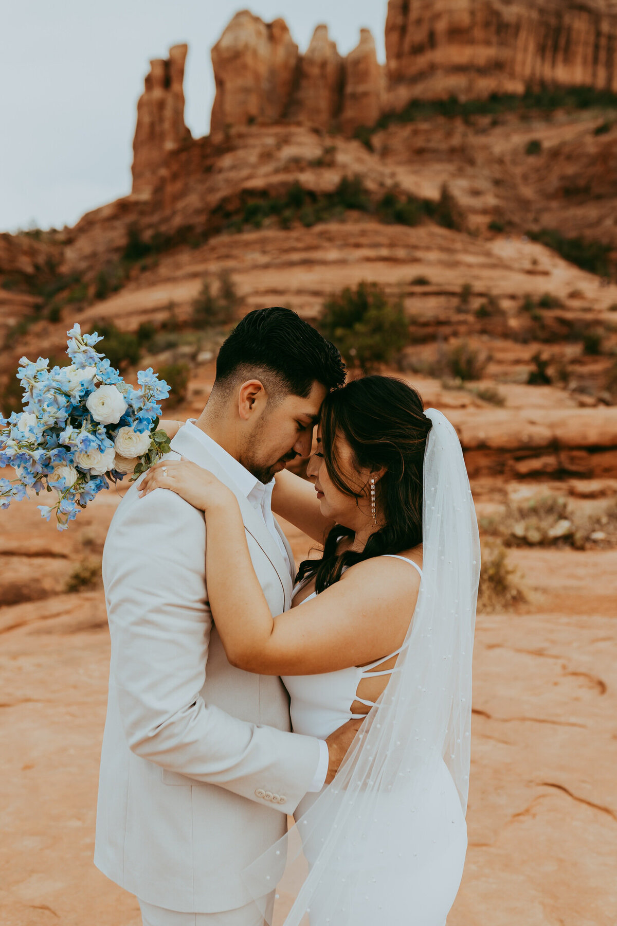 bridal couple holds eachother in front of sedona backdrop