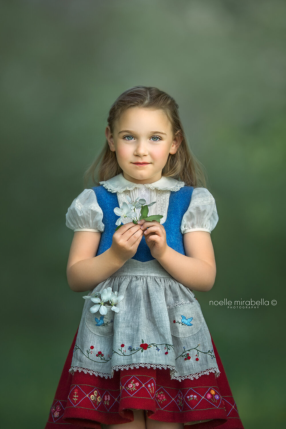 Girl in traditional German style dress with hand embroidery, outdoors.