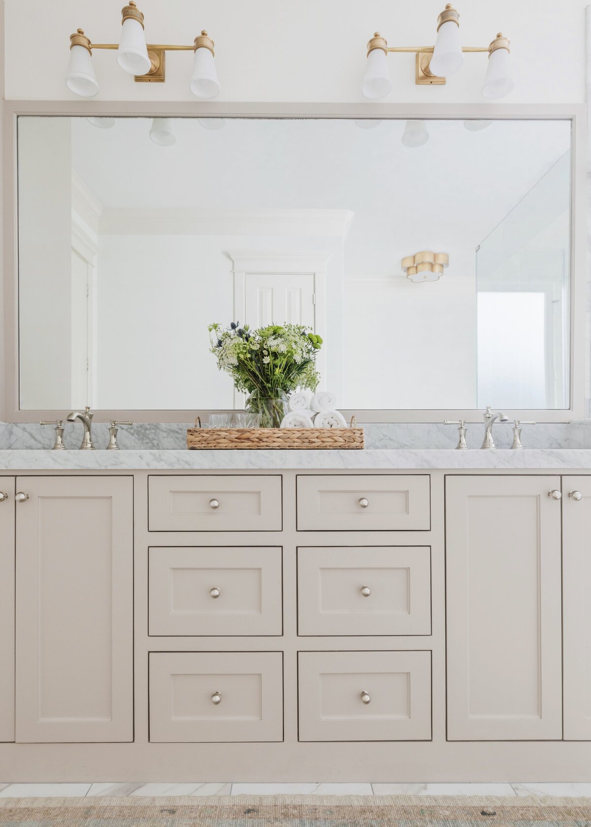 oyster creek studios oak forest remodel  tan vanity with marble countertops and wicker basket