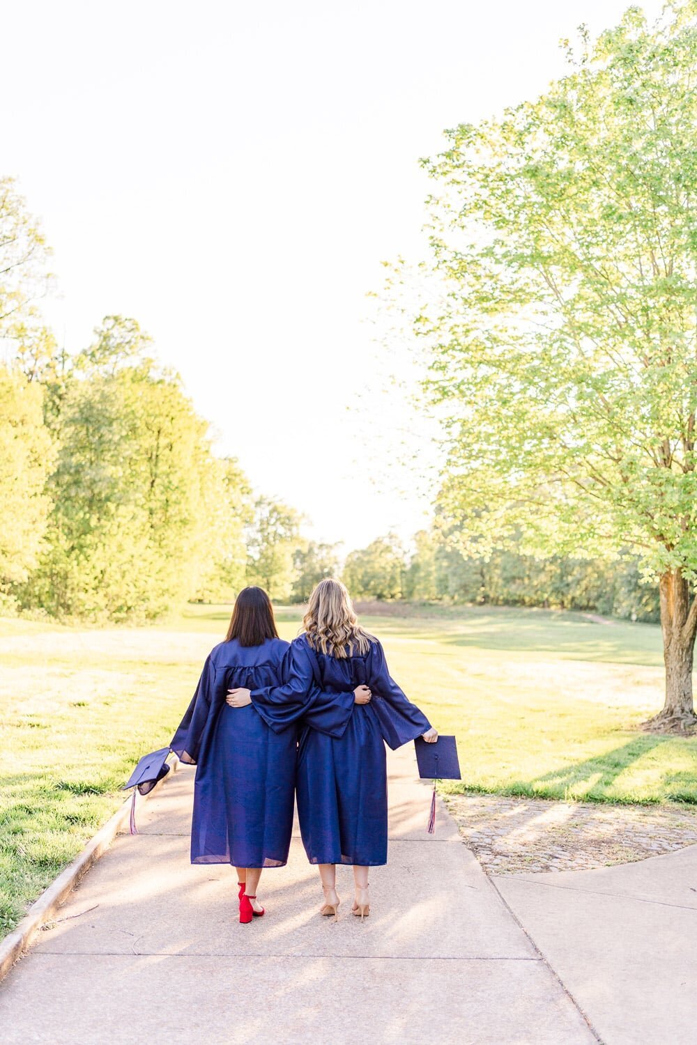 best friends wearing graduation cap & gown during senior photography in Gainesville, VA