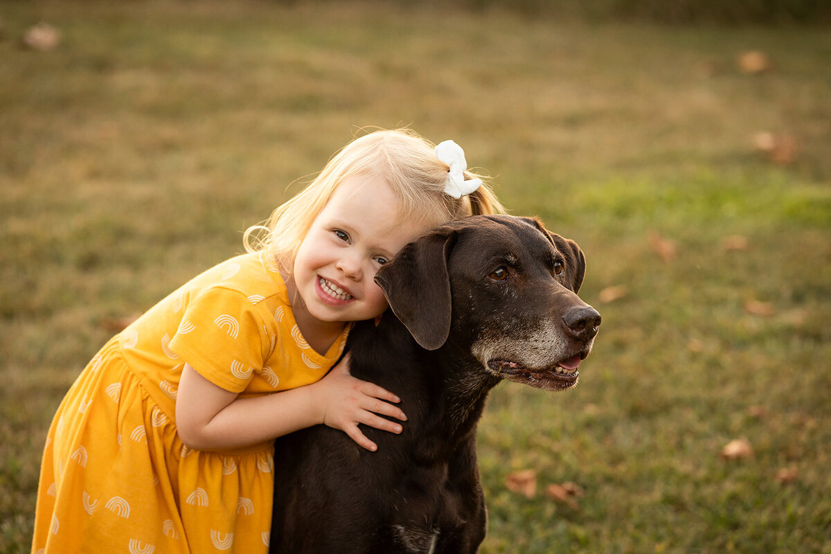 little girl hugging old dog