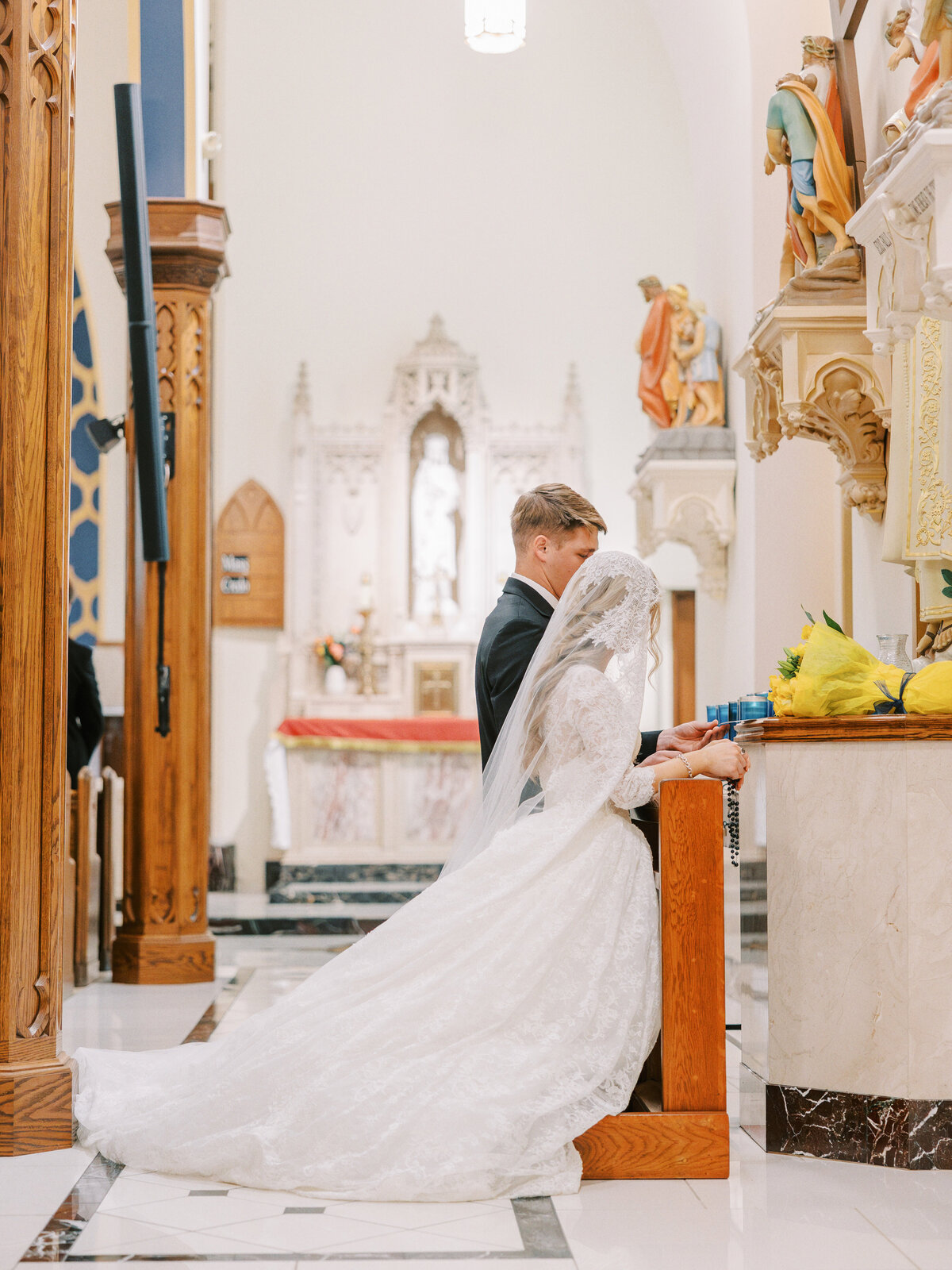 Bride and room praying at altar at traditional Latin Mass wedding at Our Lady of the Assumption Church in Walton, KY