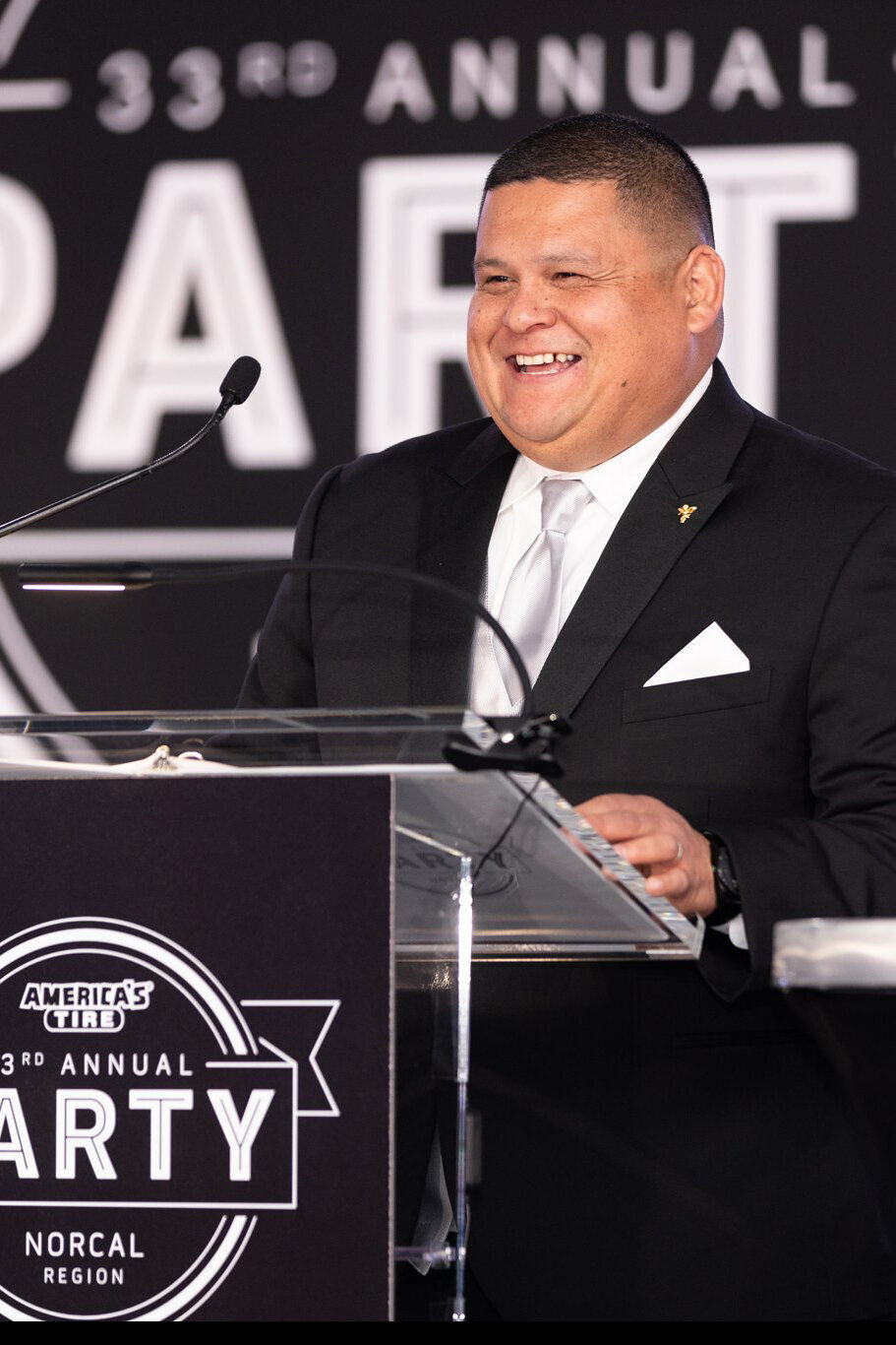 Man in tuxedo accepts award at corporate event for America's Tires