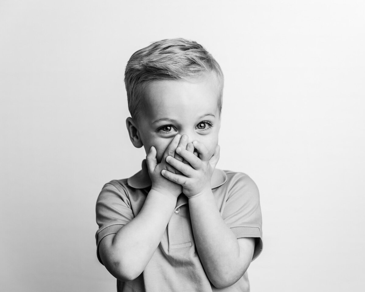 little boy covering mouth with hands long island family photographer