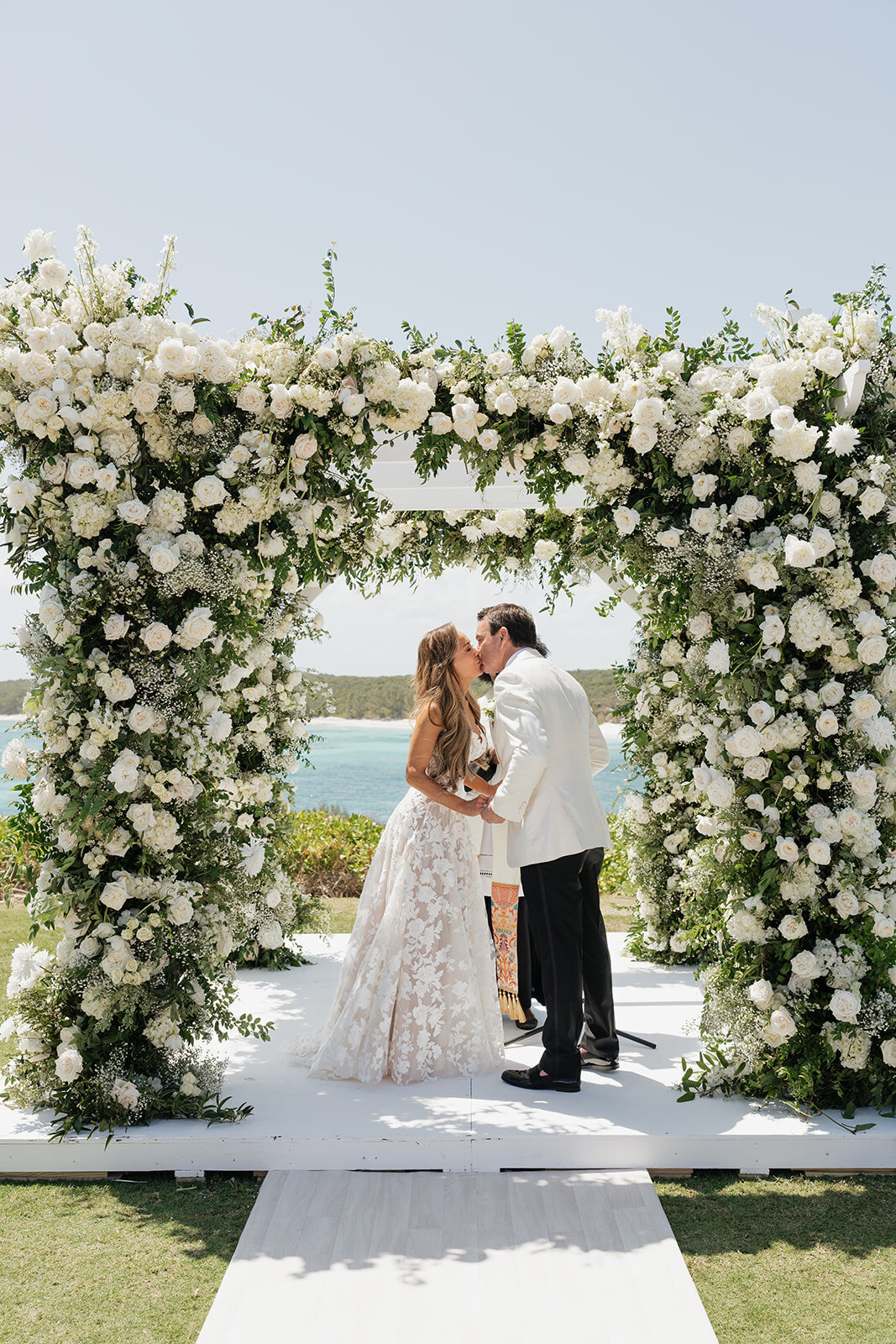 Lush floral design for wedding ceremony chuppah in Eleuthera, Bahamas. Elegant and timeless white and green floral design for island wedding on oceanside cliff. Destination floral design by Rosemary & Finch Floral Design in Nashville, TN.