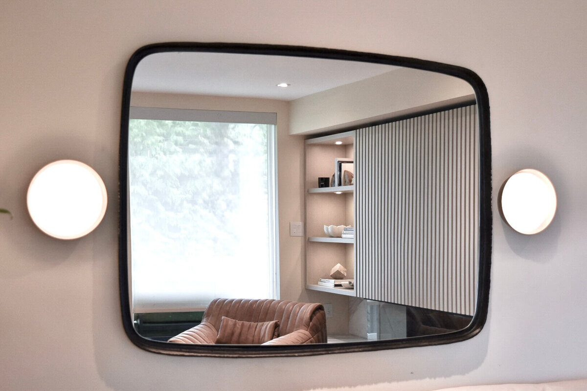 mirror reflection of fireplace surround and millwork shelves in ranger crescent living room renovation