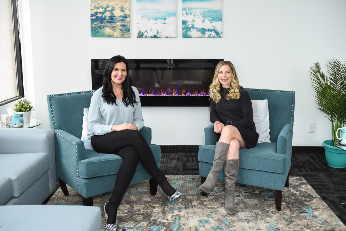 two therapists sitting in clinic in front of fireplace