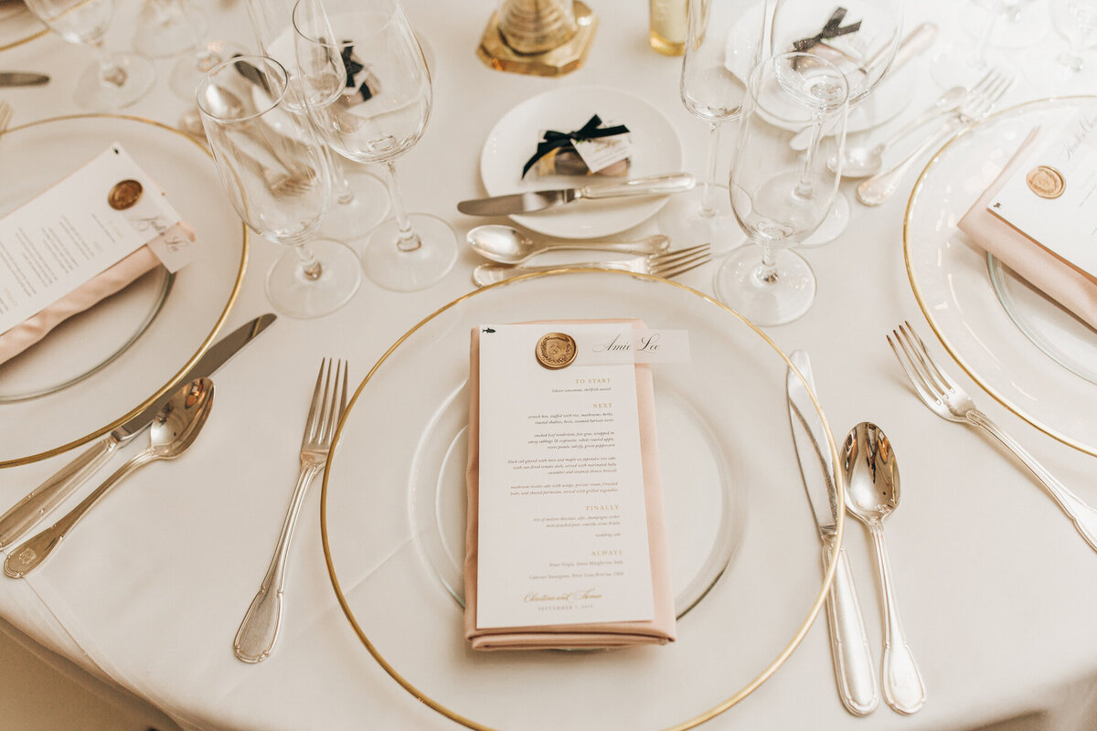 Gold, pink, and ivory dinnerware at luxurious wedding dinner