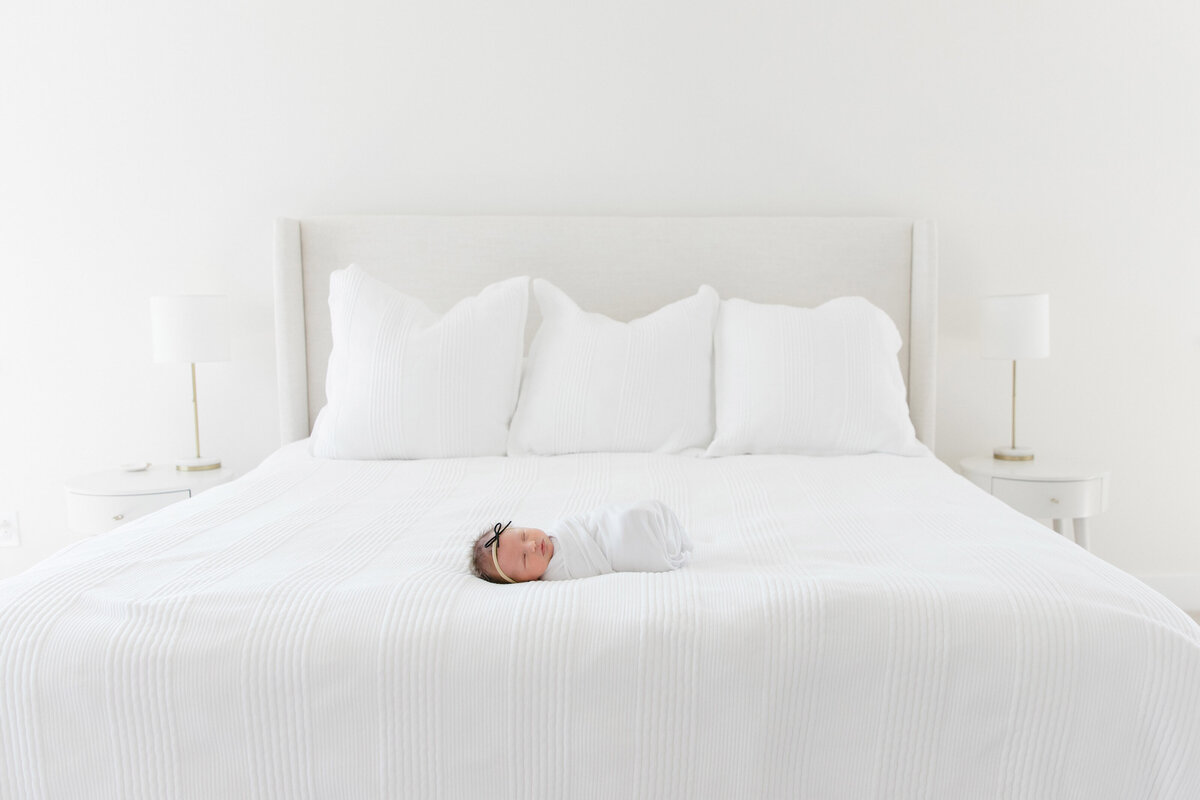 baby laying on bed during lifestyle newborn session