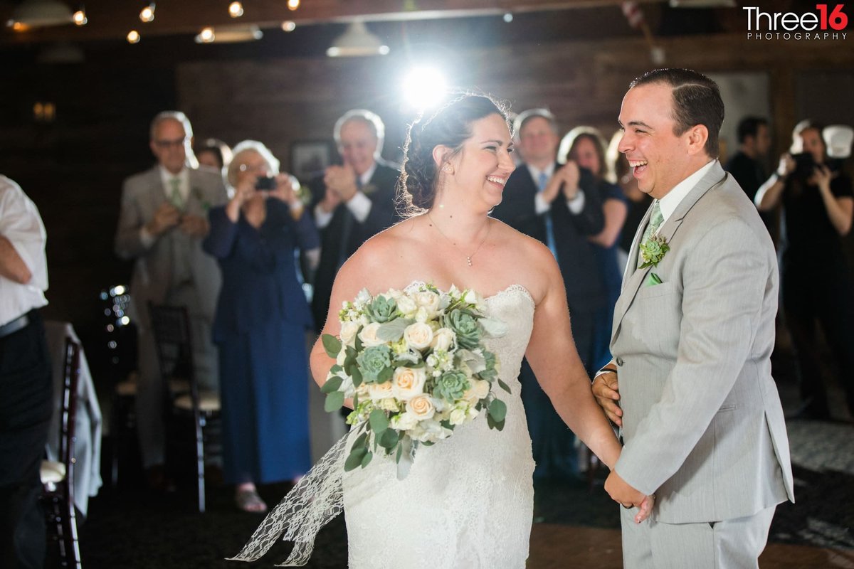 Big smiles from the Bride and Groom as guests cheer on