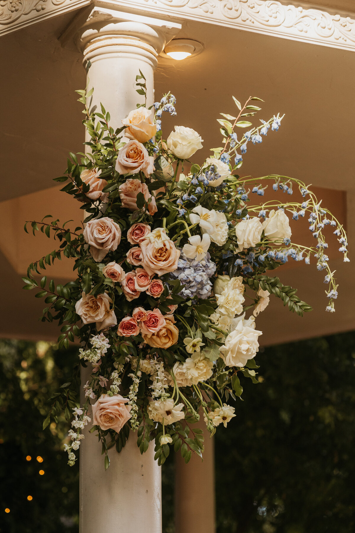 A colorful floral arrangement on the side of a gazebo 