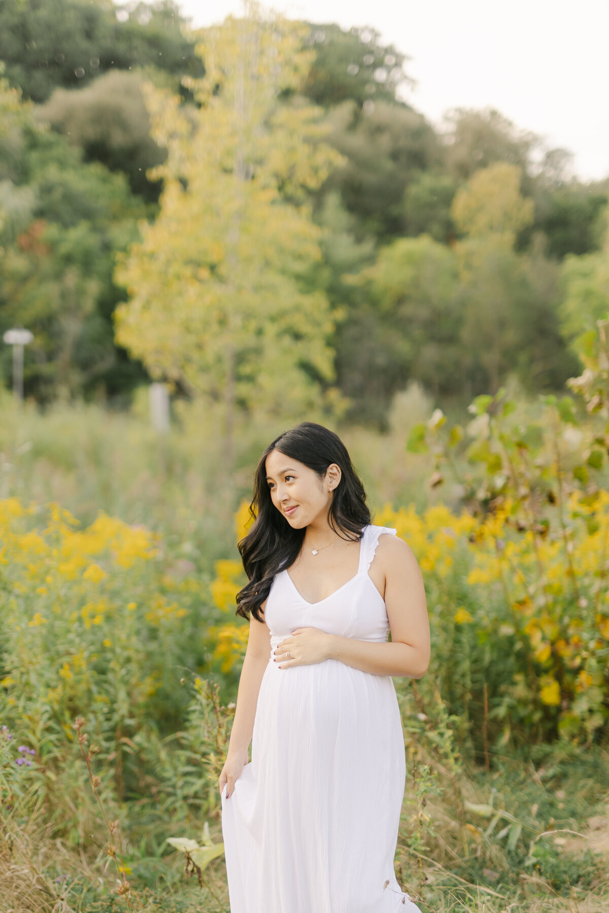 pregnant woman in field with yellow flowers by Philadelphia Family Photographer