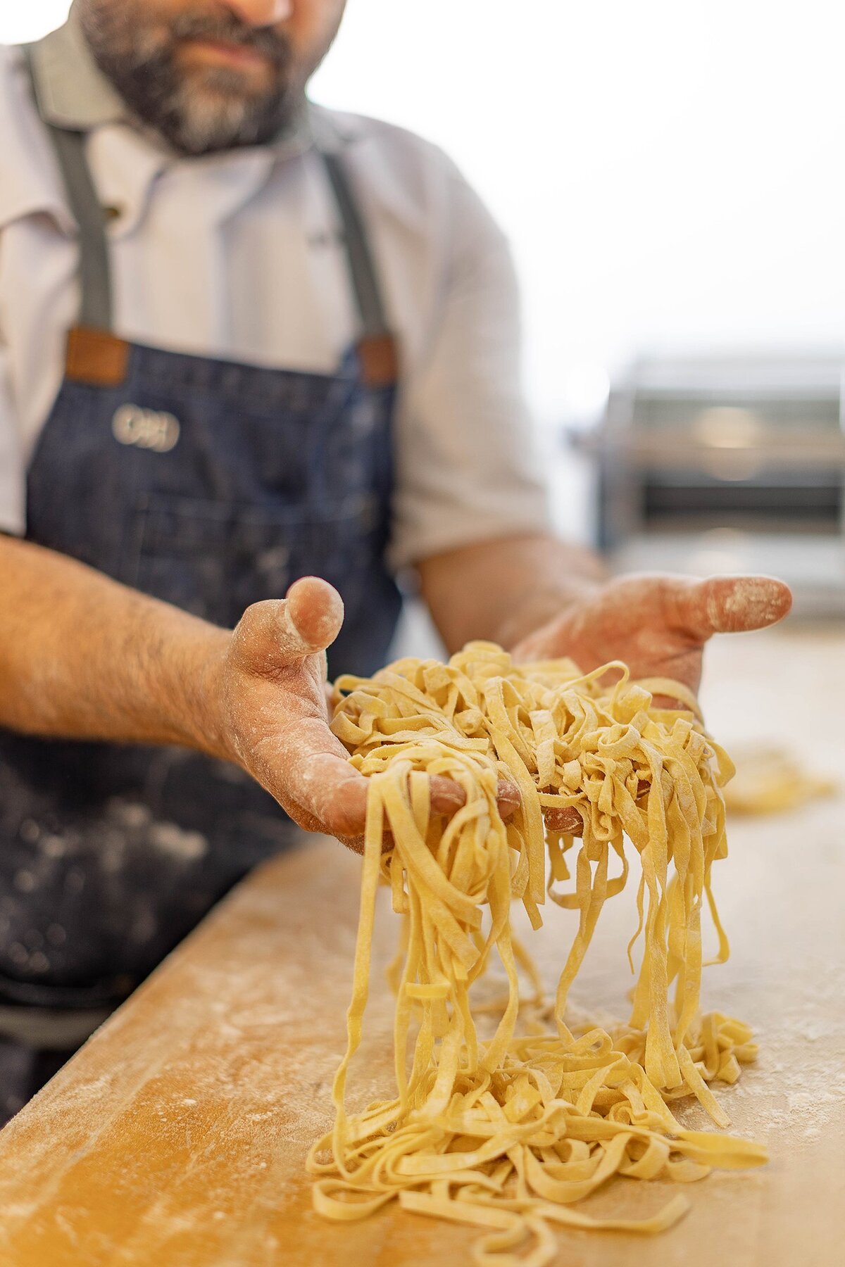 Hands holding fresh uncooked pasta