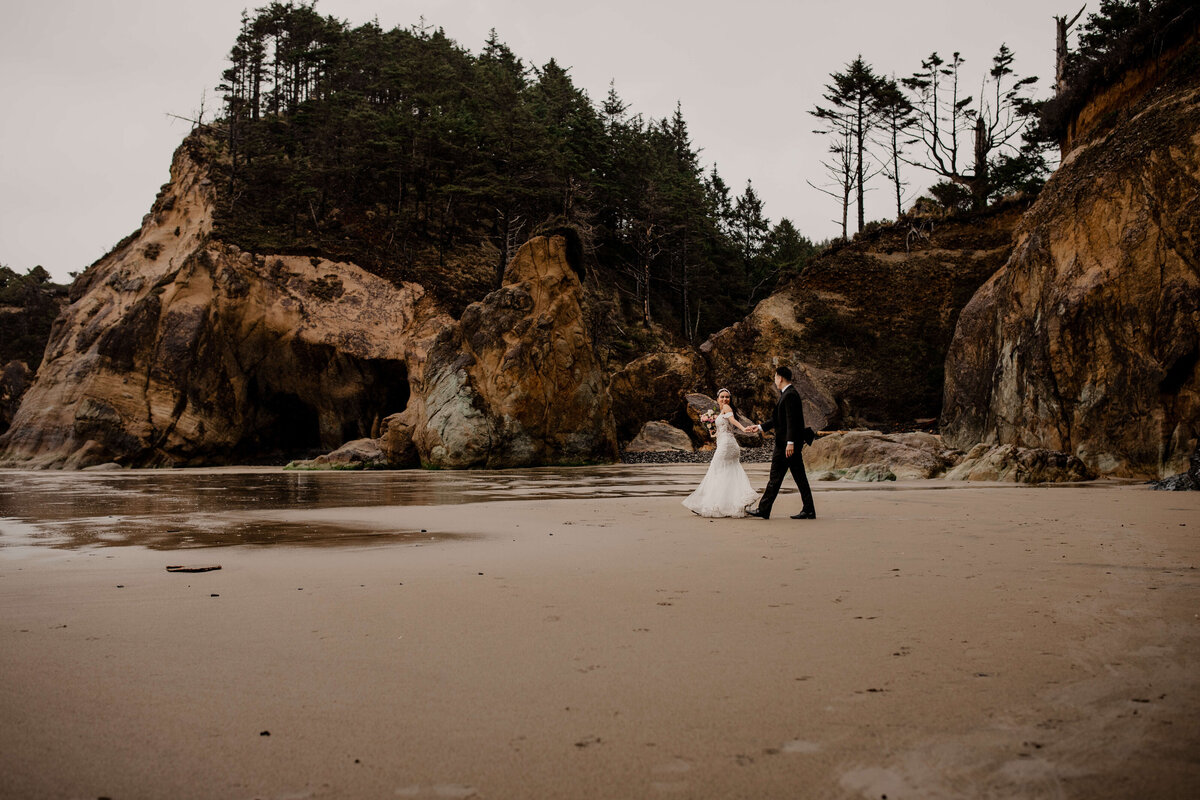 Couple walks along hug point at an Oregon coast elopement