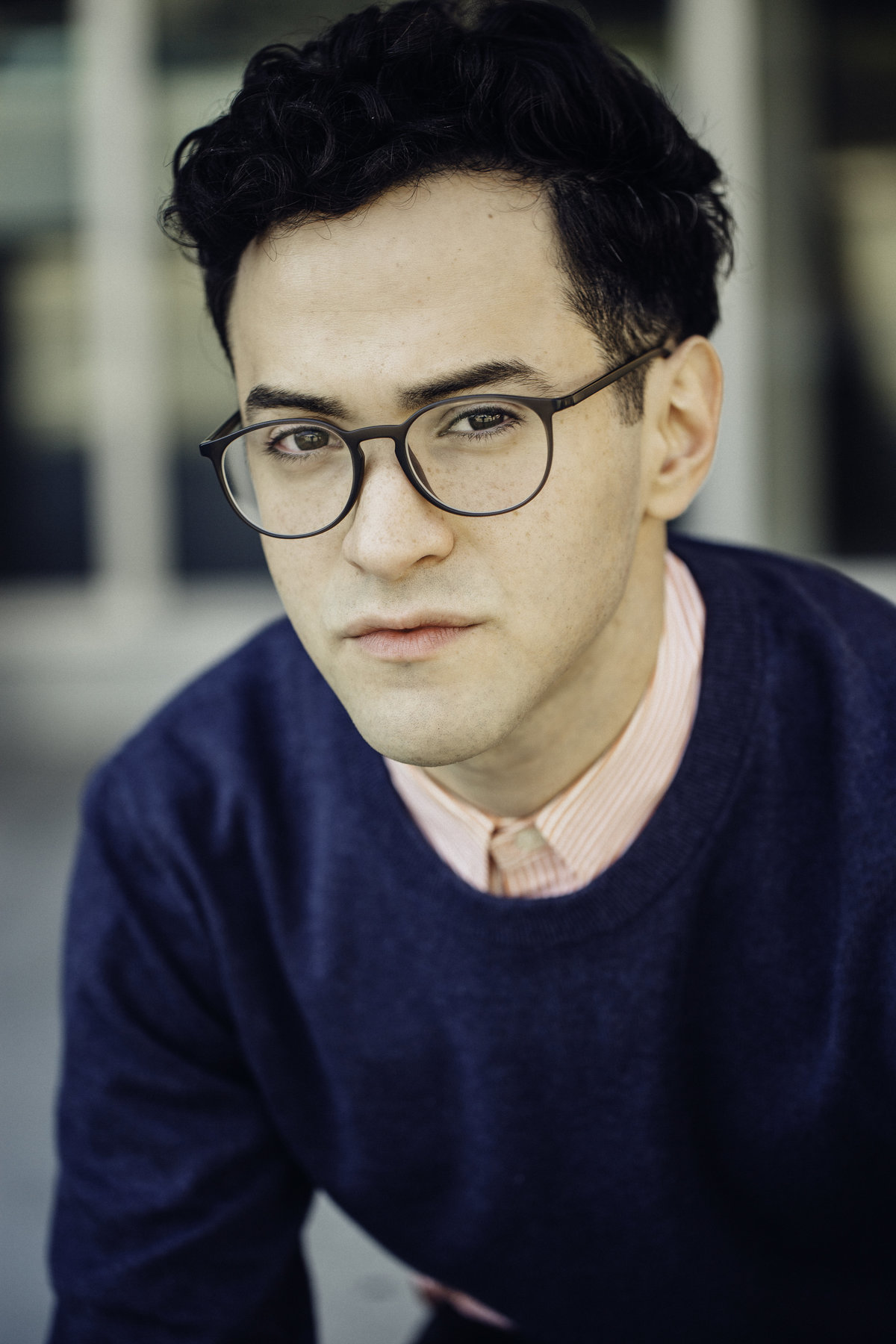 Headshot Photograph Of Young Man In Outer Dark Blue Sweat Shirt And Inner Orange Stripes Long Sleeves Los Angeles