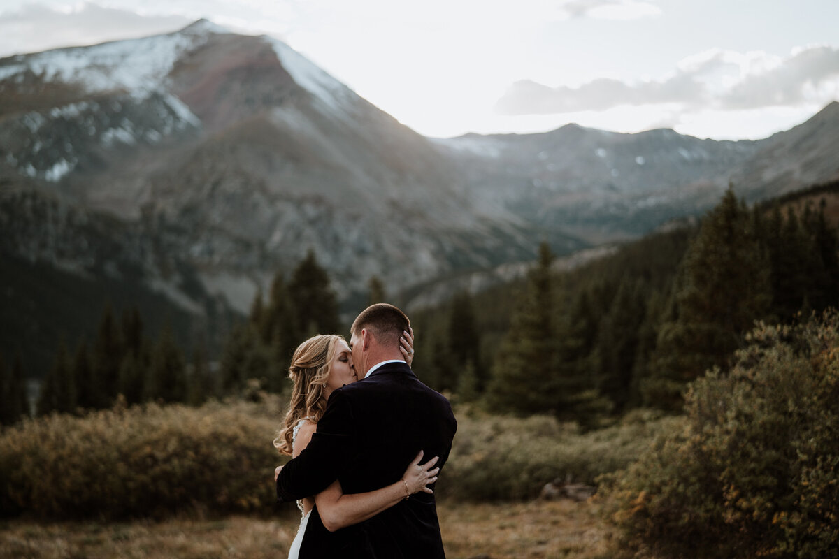 Mountain couple shares a kiss at sunset during their wedding in Hoosier Pass.