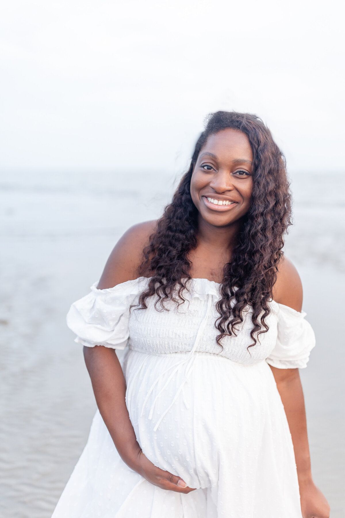 a beautiful pregnant mom to be looks at the camera with a bright radiant smile