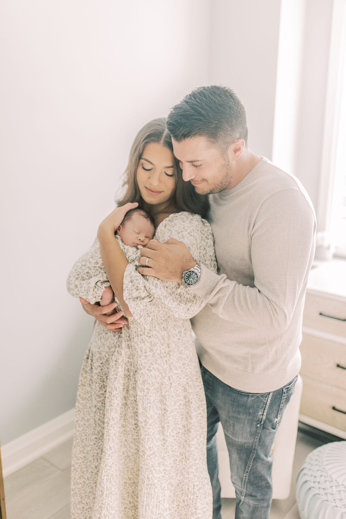 New parents embracing their newborn in soft natural light – tender in-home family moment in Vaughan, Ontario