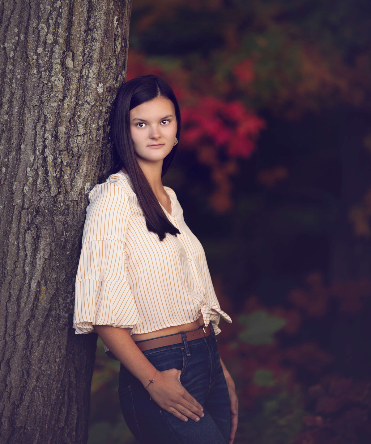Senior photo of a girl leaning against a tree on Penn State Behrend campus in Erie Pa