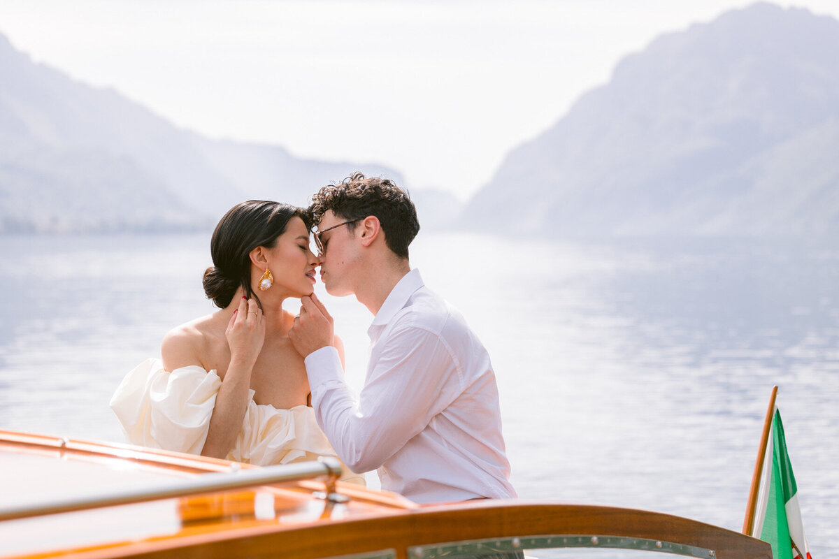 how-to-elope-in-italy-lake-como-couple-kissing-wooden-boat-moon-rising-photography-lake-como-elopement-italy-italian-elopement-photographer-8026