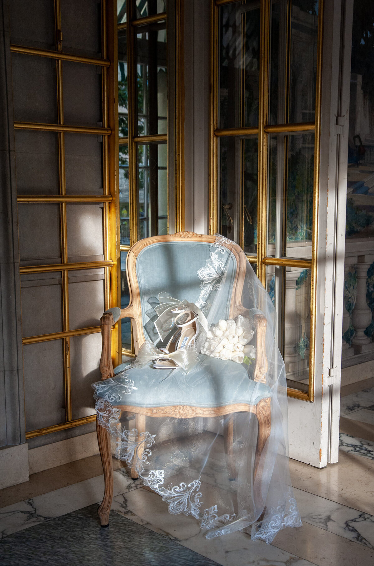 blue velvet chair with a bridal veil and white jimmy choos sitting on top