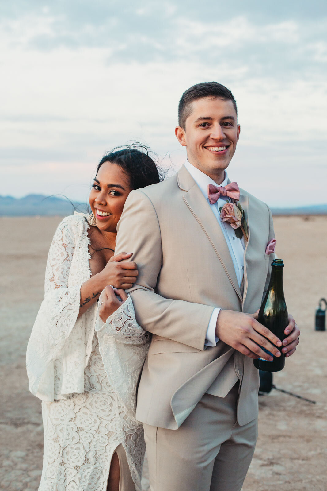 Couple popping champagne in the desert