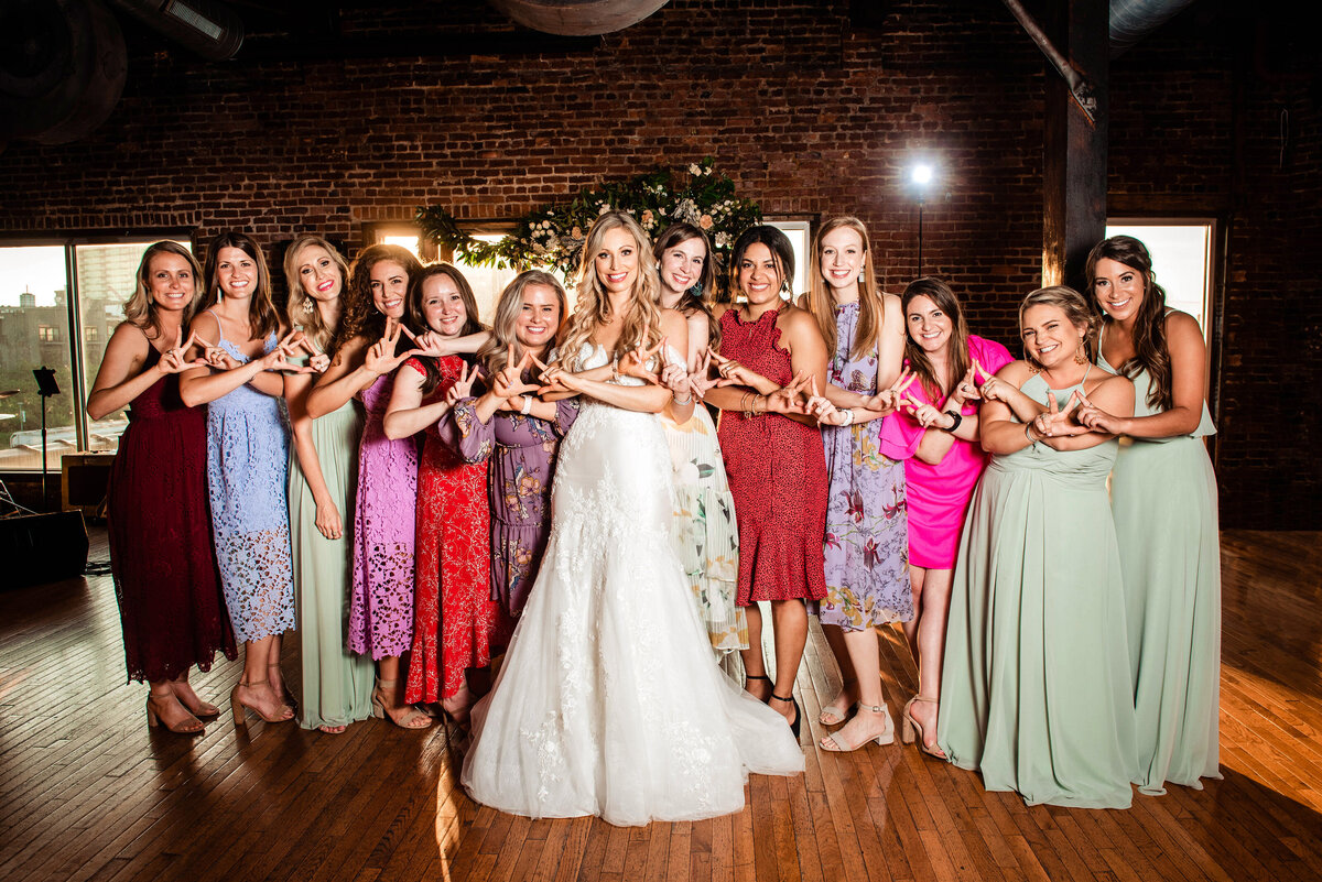 Bride taking group photo with her sorority sisters during wedding reception at Cannery ONE, they are throwing their sorority letters