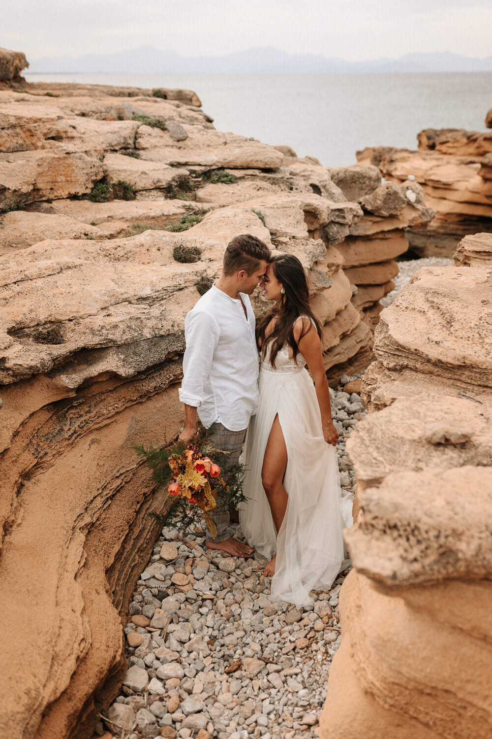 Brautpaar zwischen Felsen an der Küste von Mallorca