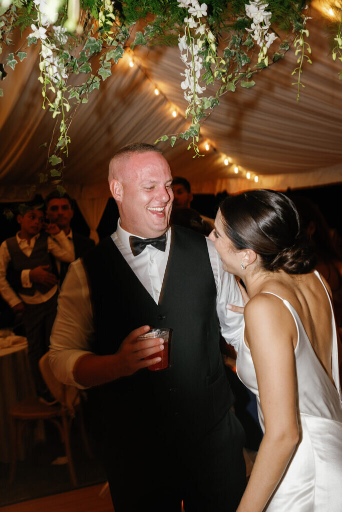 A candid moment of joy as the newlyweds share a laugh while celebrating their wedding night. Captured by Claudia Amalia Photography in the Florida Keys.