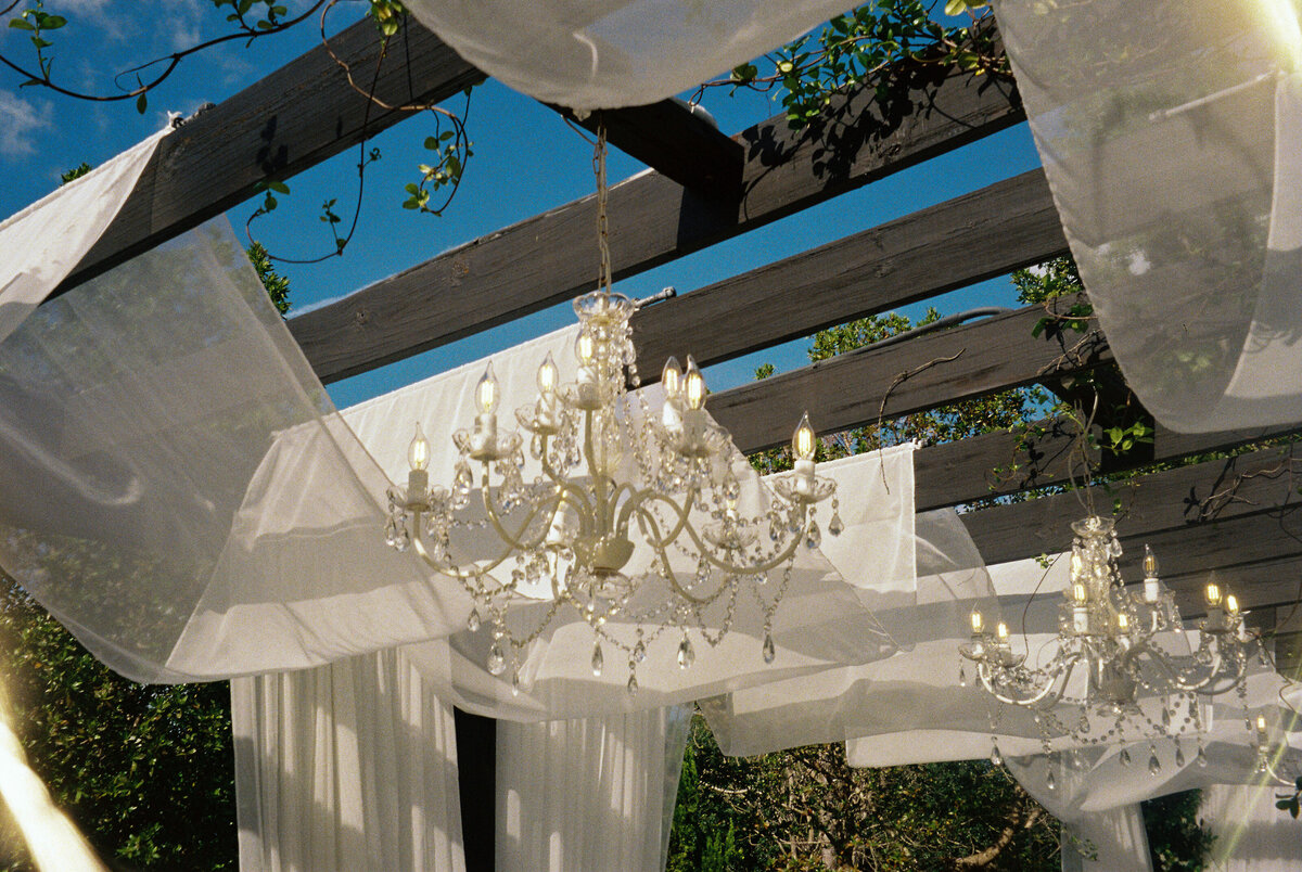 Elegant outdoor reception under chandeliers at La Casa Toscana wedding 