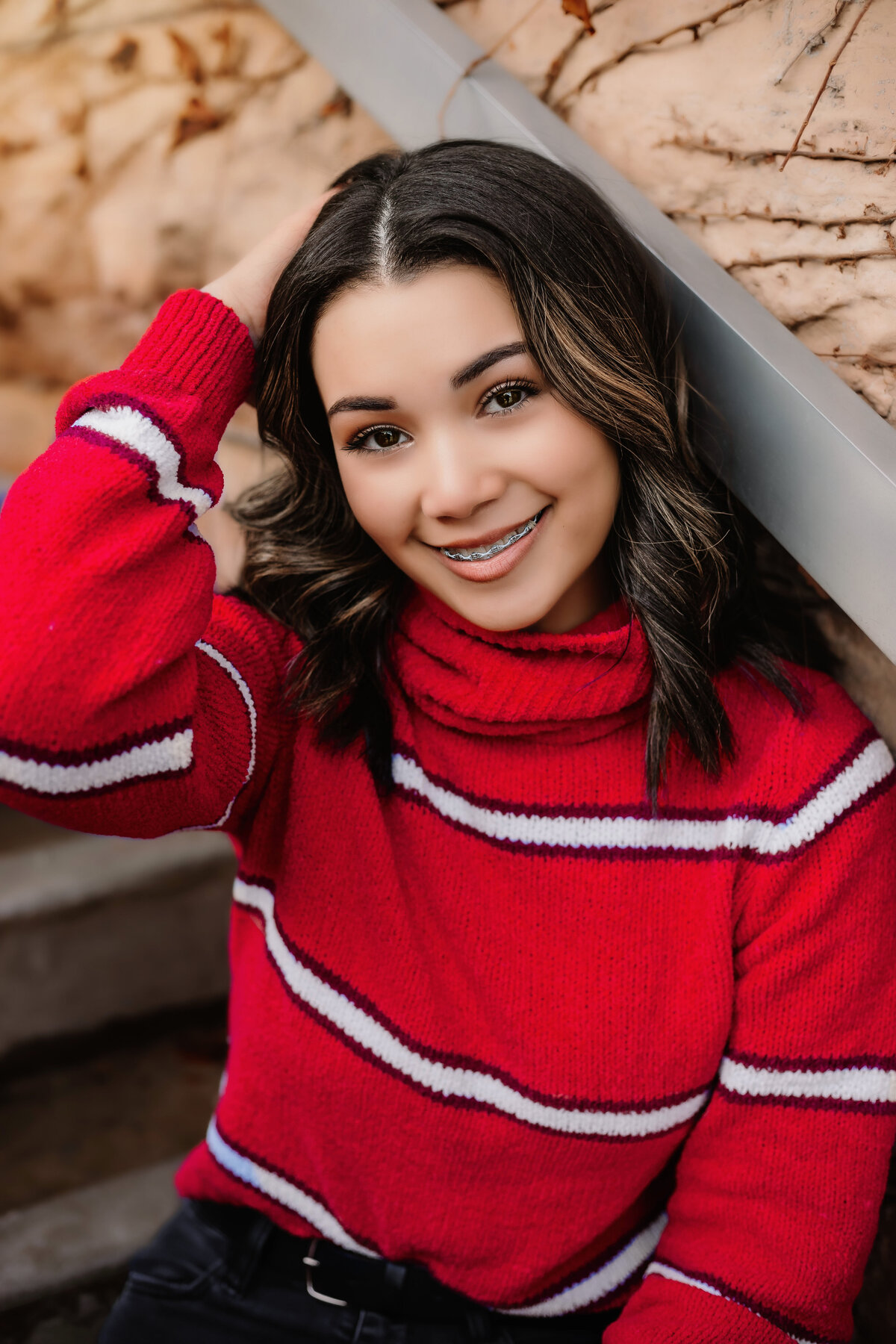 This senior sports a smile while posing downtown for senior photos.