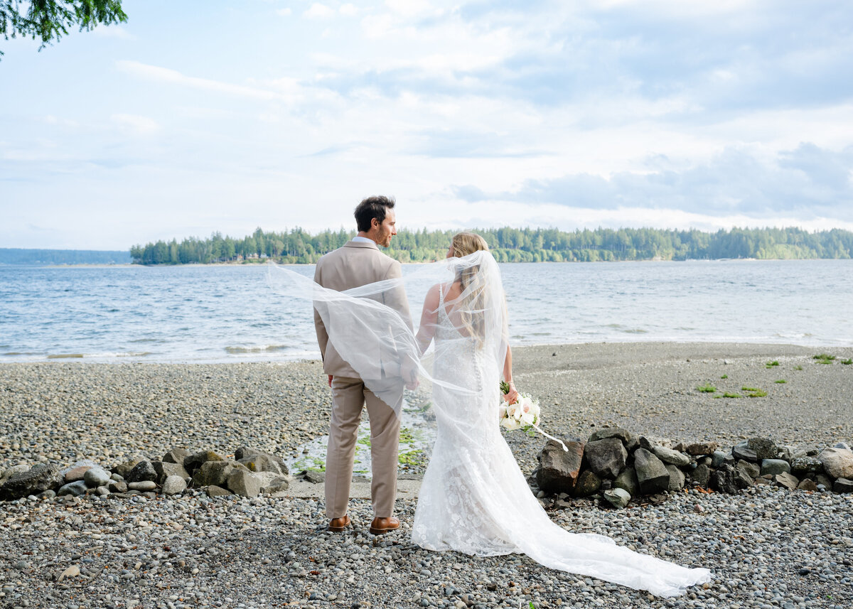 wedding couple portrait on the beach looking at puget sound