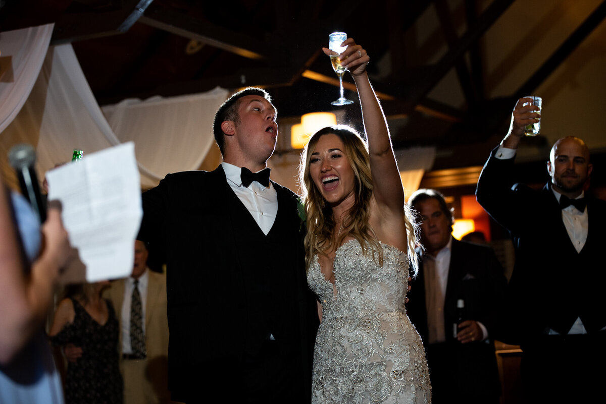 Bride and groom cheer after toast at their reception