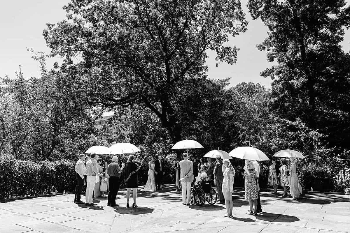 A summer wedding on the Conservatory garden in peak summer with umbrellas for shade.