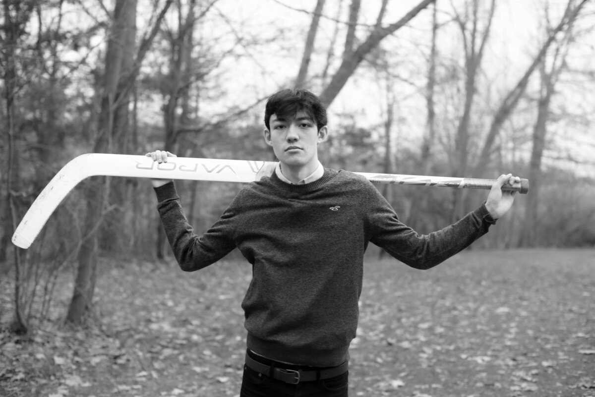A senior poses with his lacross stick over his shoulders at Endicott Park.