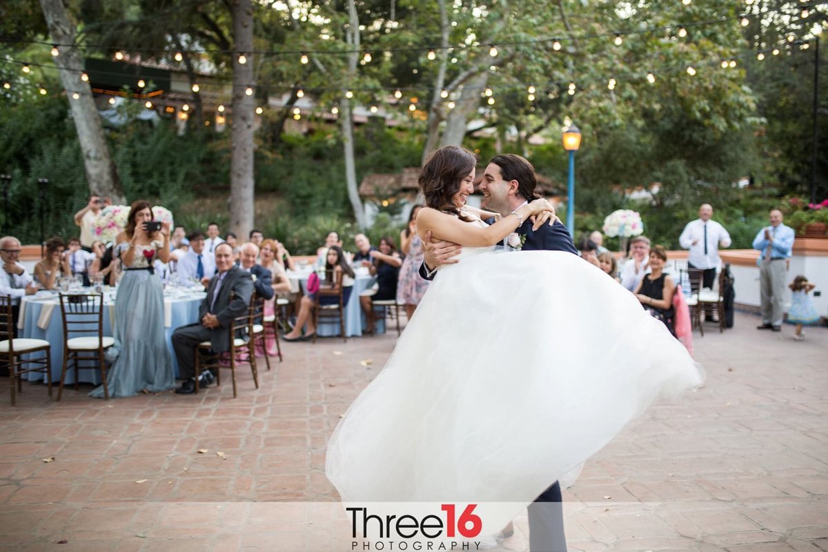 Groom lifts his Bride during their first dance