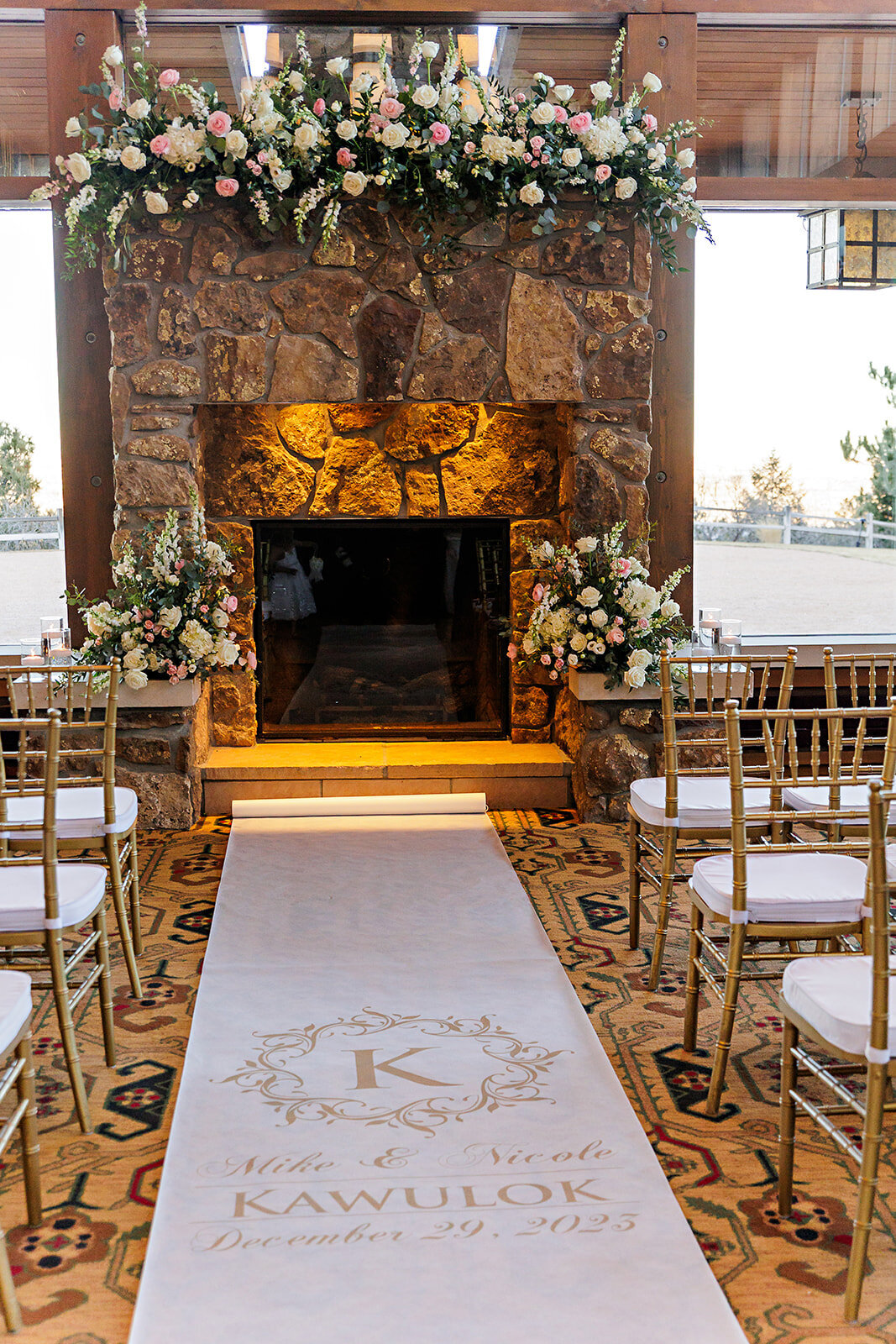 Wedding Ceremony setup with white, blush, sage, and pink flowers with a white aisle running with a custom wedding monogram at the Broadmoor Hotel in Colorado Springs, Colorado.