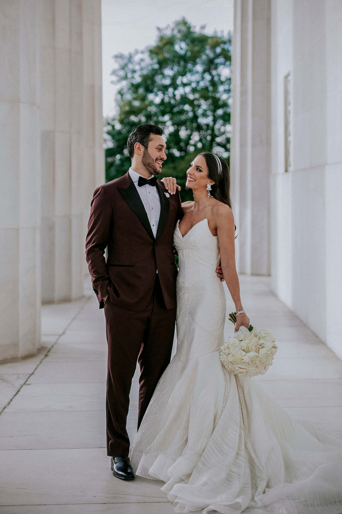 man-in-tuxedo-and-woman-in-white-dress-holding-white-bouquet