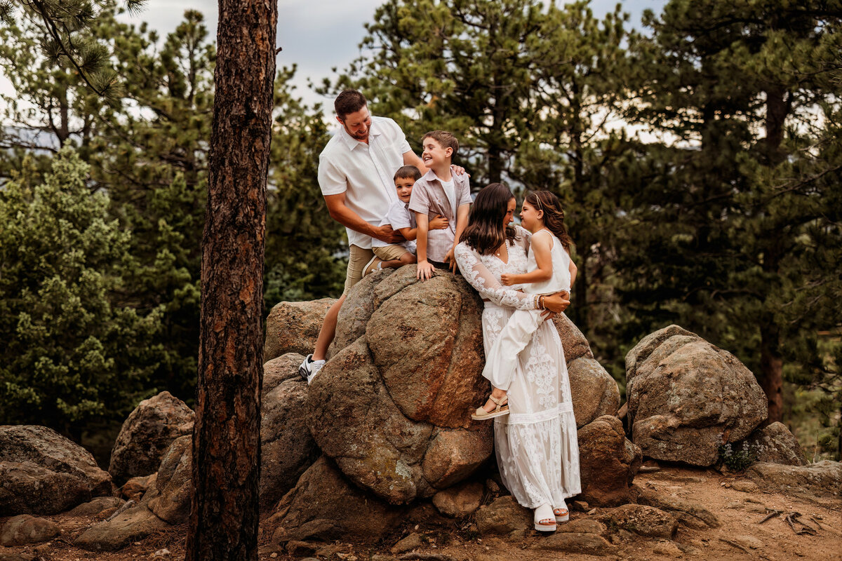 Family of five pile on large rocks and boulders in Colorado for their summer family session