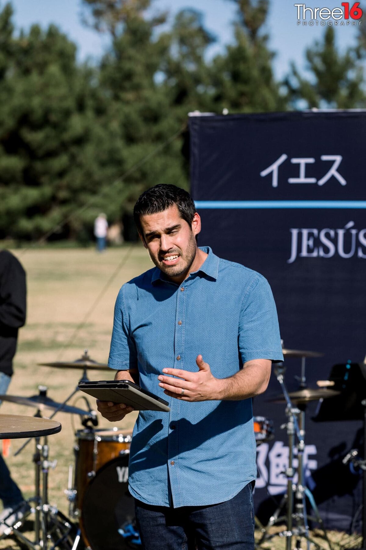 A pastor speaks to a group of people at an outdoor event