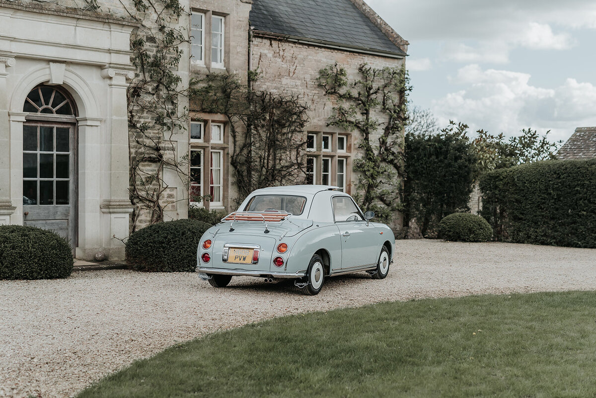 Light blue vintage car parked on cobbled pathway outside Euridge Manor