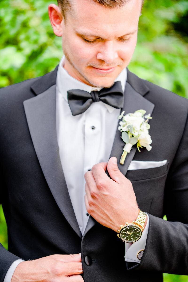 close up of groom and his classic black suit
