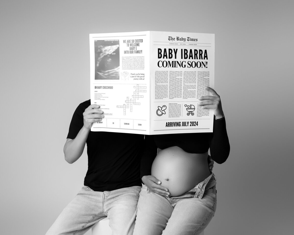 Creative pregnancy announcement with custom newspaper prop and parents in jeans and black tops.