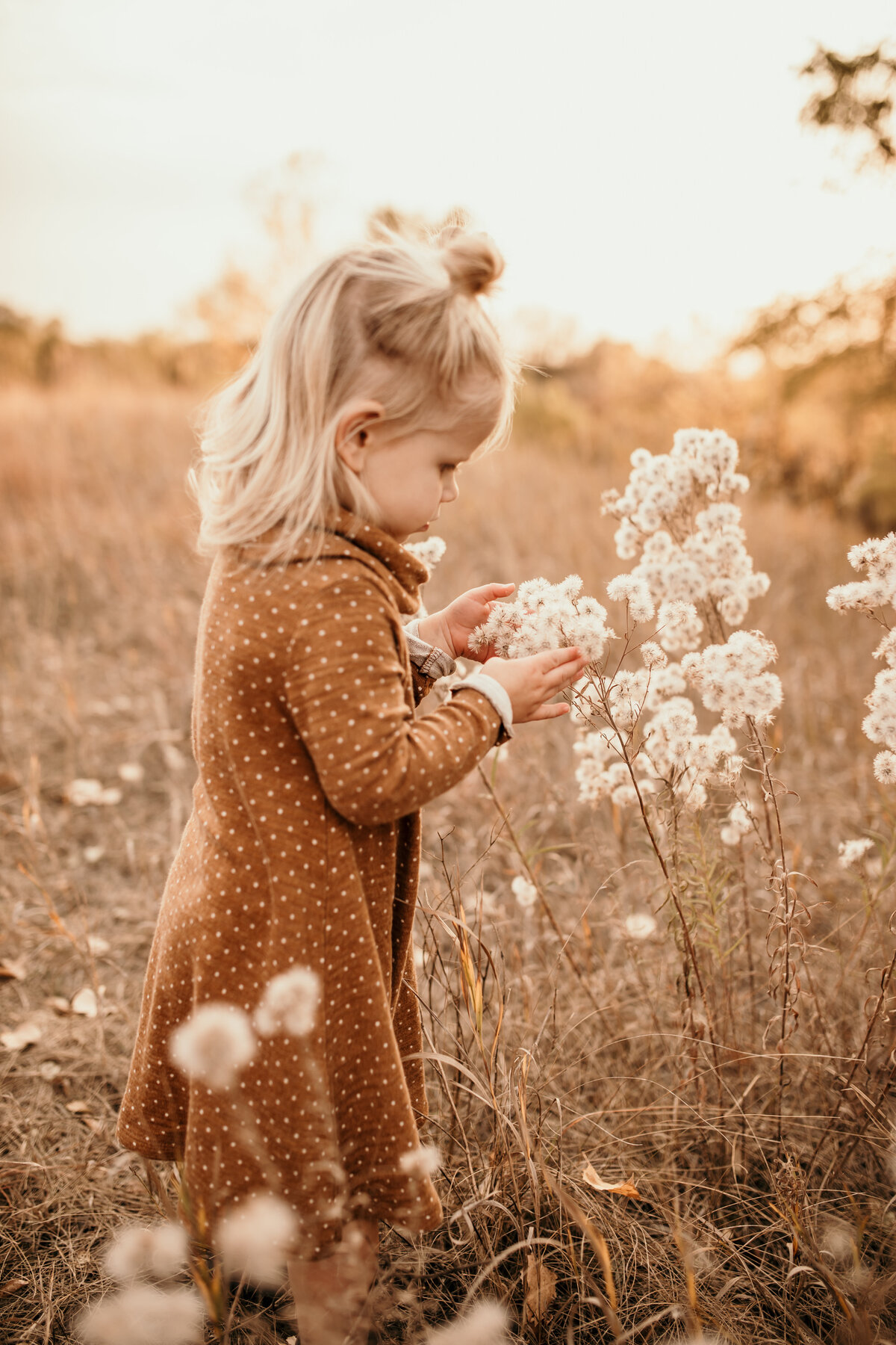 Little girl playing in flowers.