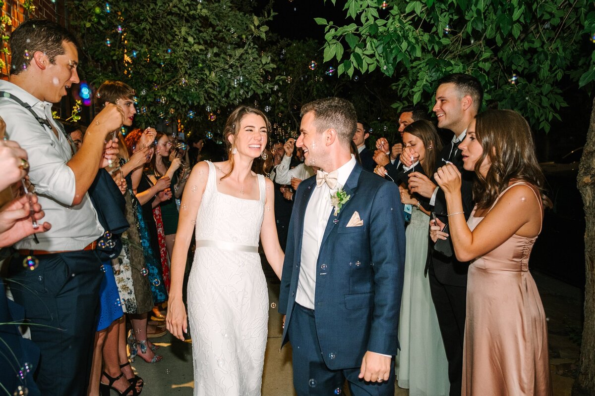 Bride and groom surrounded by bubbles for their grand exit.