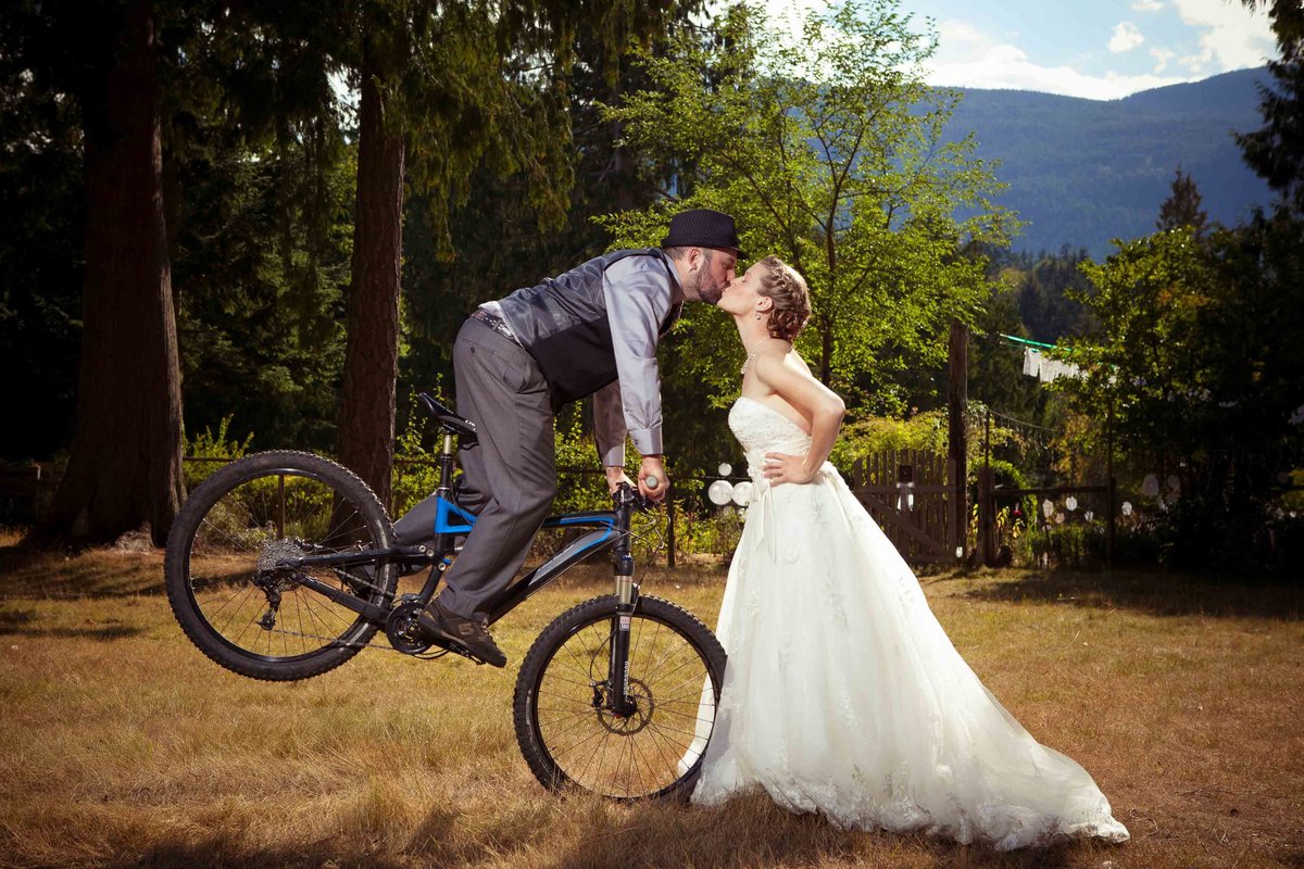 Groom Kissing Bride on Mountain Bike