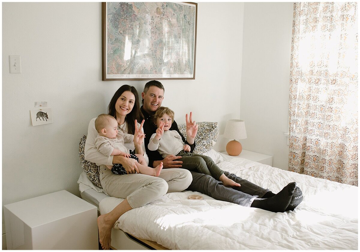 Family sitting on bed with baby and toddler at sweet home family session in Austin by Amber Vickey Photography